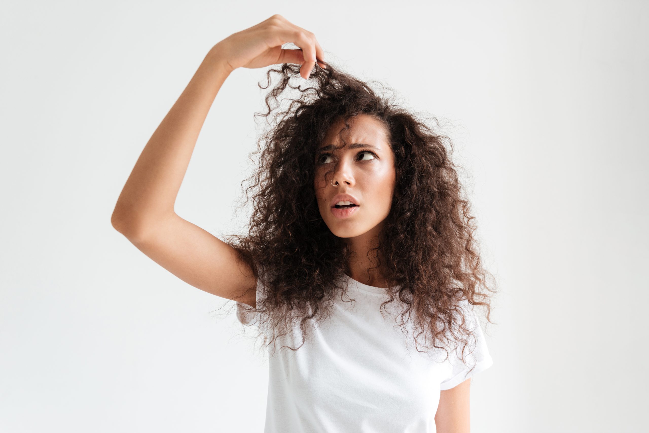 portrait confused young woman looking her hair scaled